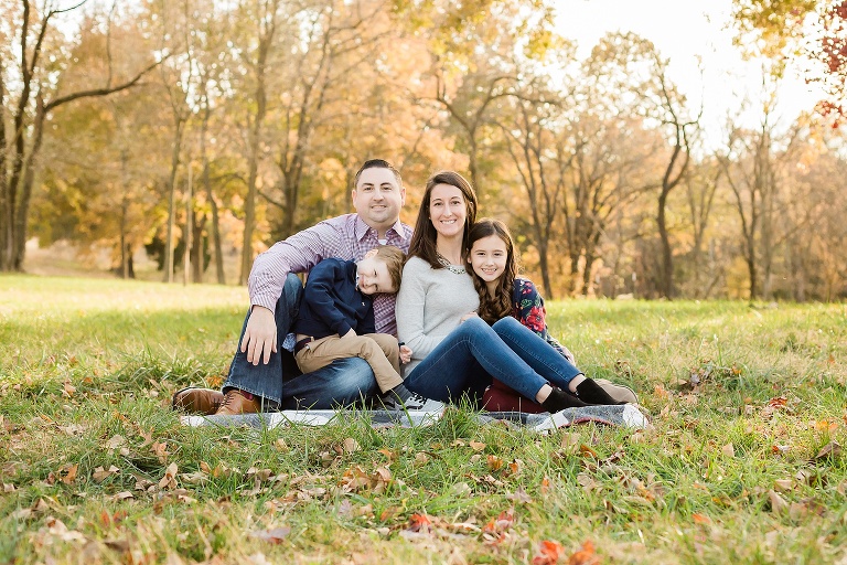 Beautiful family of four sitting on a blanket on fall evening | KGriggs Photography