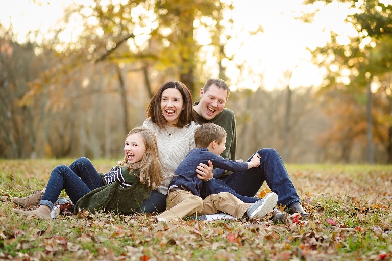 Mom, Dad, and kids sitting in park laughing together | KGriggs Photography
