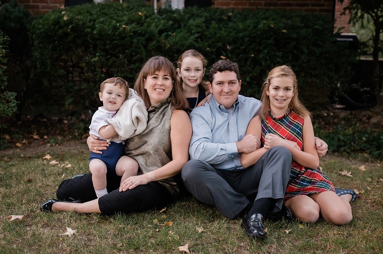 Family of five sitting on grass smiling at camera | St. Louis Family Photography