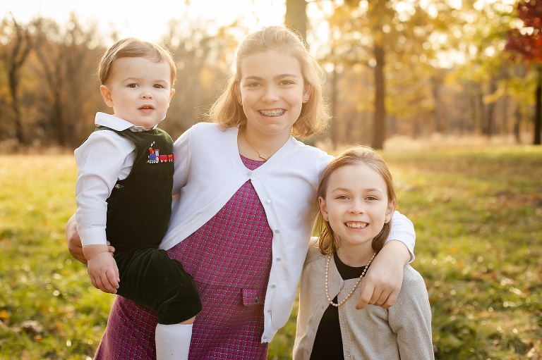 Two young sisters and baby brother smiling at camera | St. Louis Photography