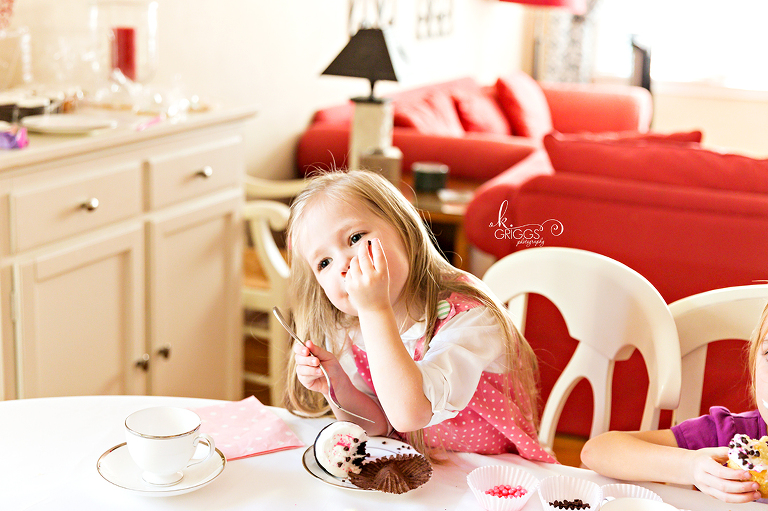 Little girl sitting at table eating cupcake | St. Louis Photography