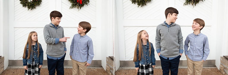 Three siblings laughing at each other in front of white barn doors | KGriggs Photography