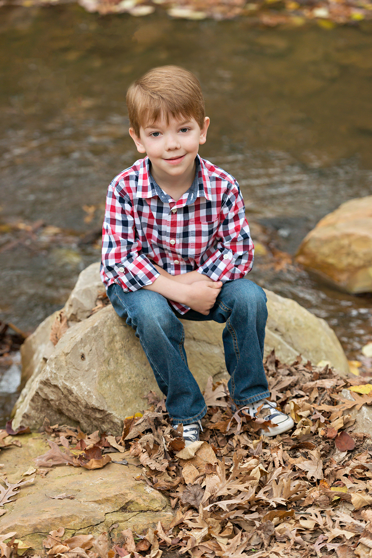 Young boy sitting by a stream | St. Louis Photography