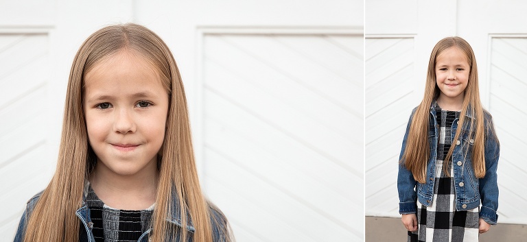 Young girl standing in front of white barn doors smiling | KGriggs Photography