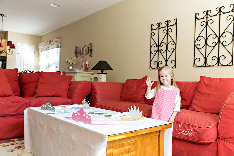Little girl standing in living room holding up her hand | Family Photographer St. Louis