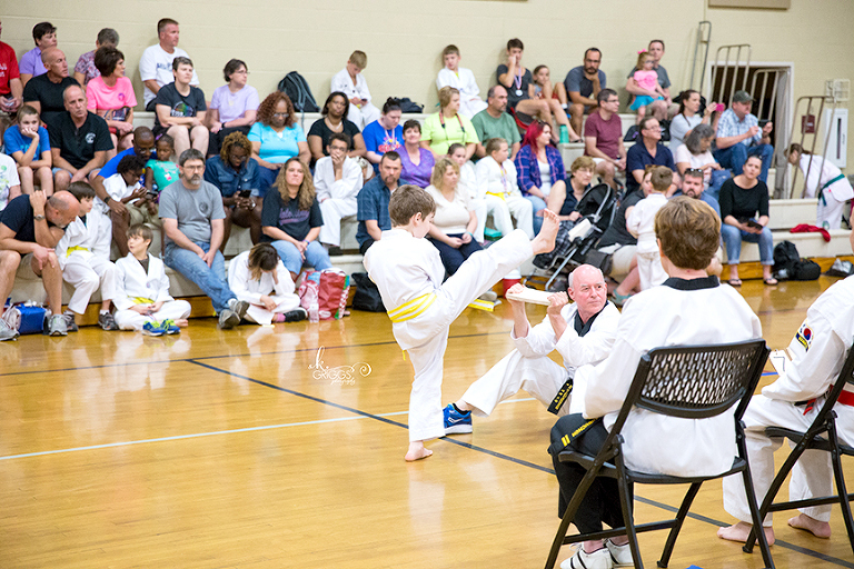 boy breaking board at tournament | st louis children's photography