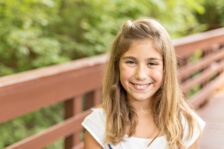 Pre teen girl in white dress smiling at camera | St. Louis Children's Photographer