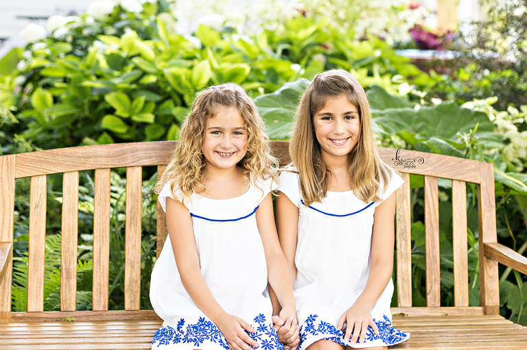 Sisters sitting on a bench in a garden. | St. Louis Family Portraits