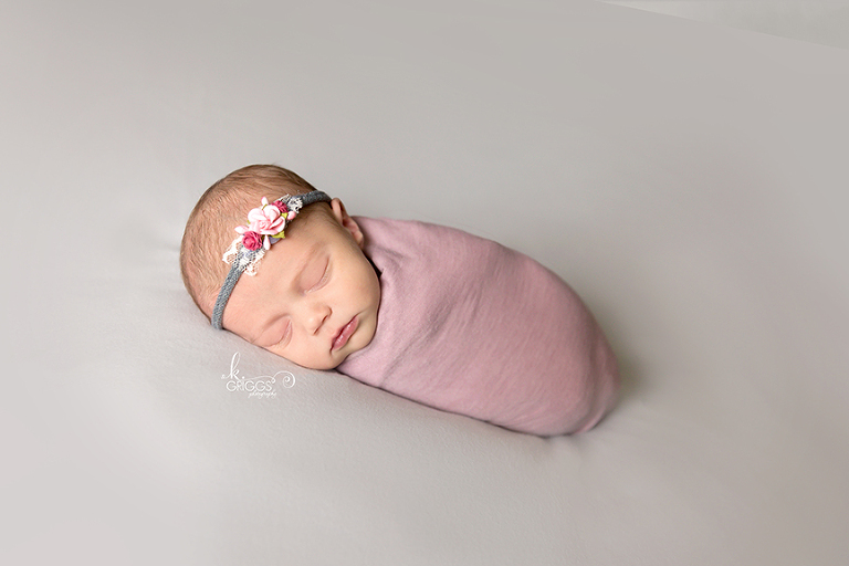 Newborn wrapped in pink wrap. | St. Louis Baby Photographer