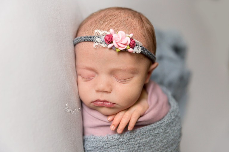 Newborn girl sleeping wearing headband. | St. Louis Newborn Photography