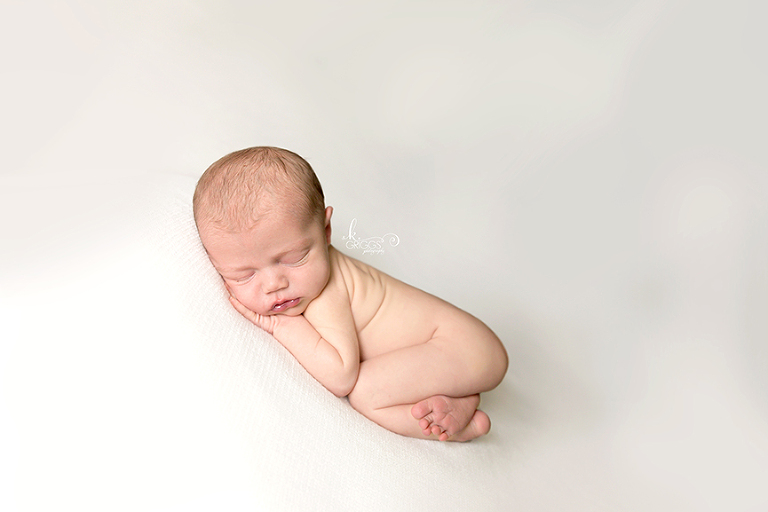 Baby girl asleep on white blanket. | St. Louis Newborn Photographer