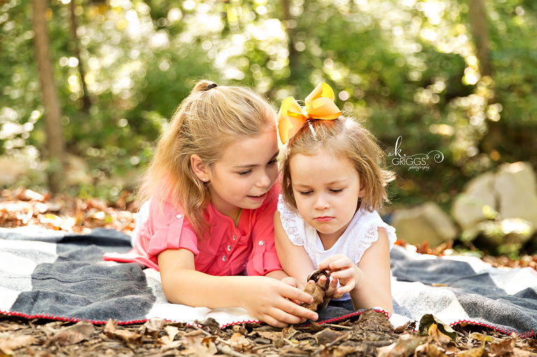 Sweet sisters laying on a blanket Longview Farm Park | St. Louis Family Photographer