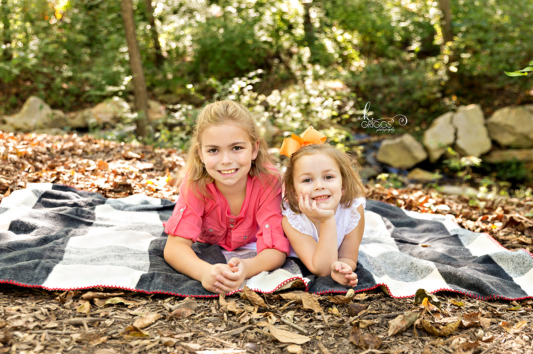 Sisters laying on blanket smiling at camera | St. Louis Family Photographer