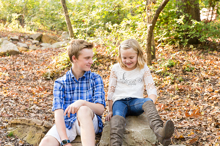 brother and sister sitting on rocks in Longview Farm Park | St. Louis Family Photographer