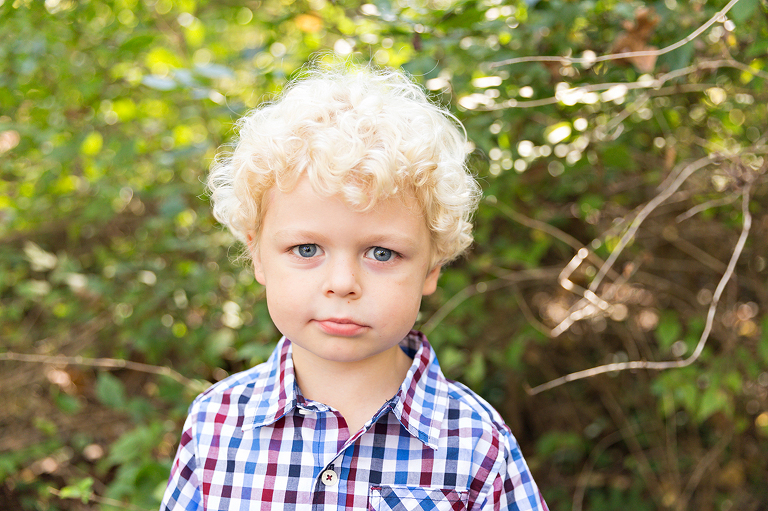 Young boy looking at camera with smirk on face - Longview Farm Park | St. Louis Photographer
