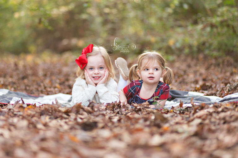 Sisters laying on a blanket on a bed of leaves | St. Louis Children's Photographer