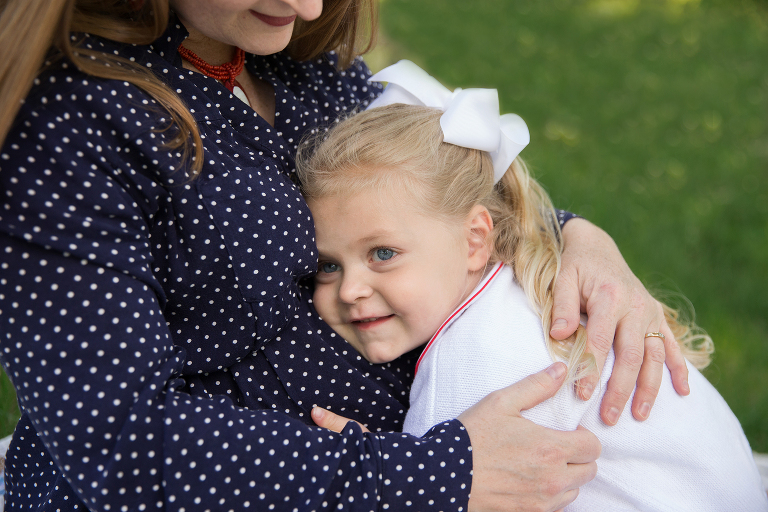 Little girl with her head on momma's tummy | St. Louis Family Photography