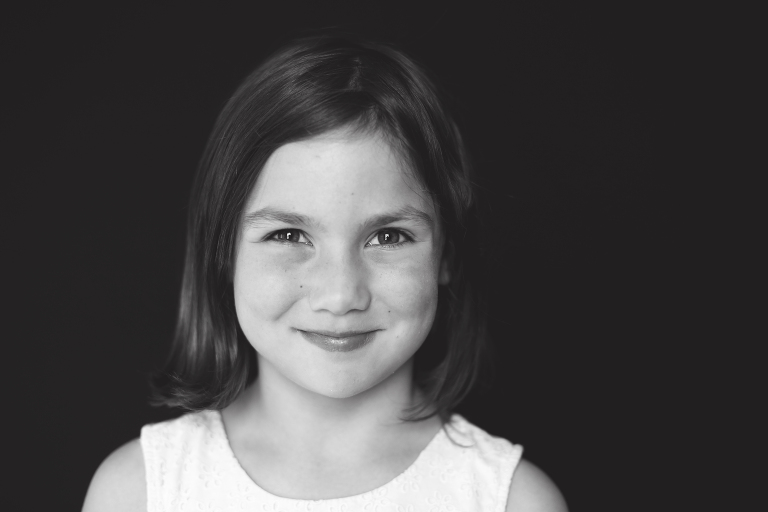 Young girl smiling and looking at camera in black and white | St. Louis School Photos