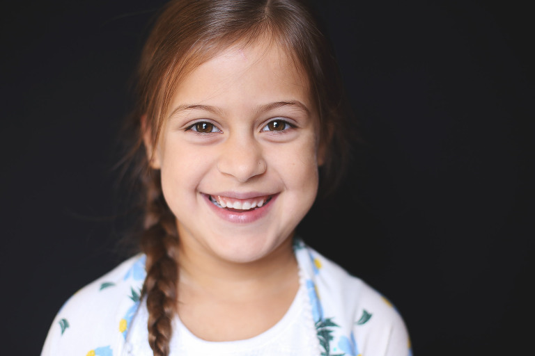 Young girl with braided hair smiling at camera | St. Louis School Photography