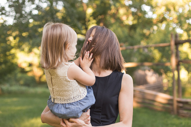 Little girl playing with mom's hair in Faust Park | St. Louis Family Photography