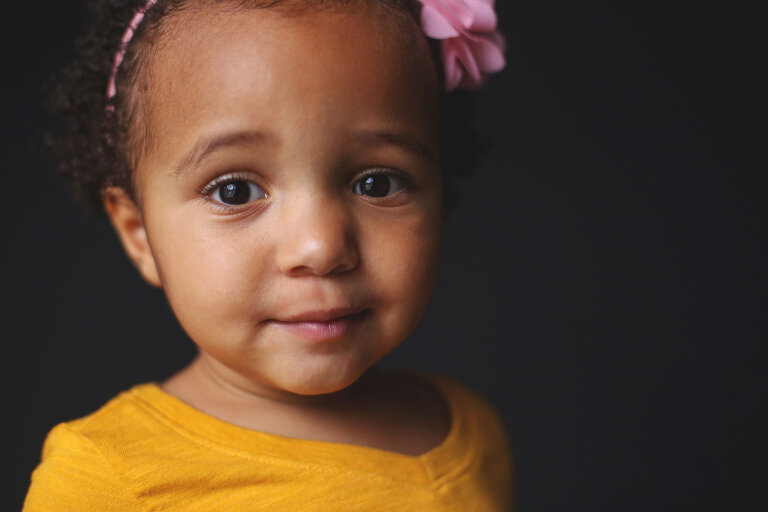 Little girl with pink headband looking at camera | St. Louis School Photography