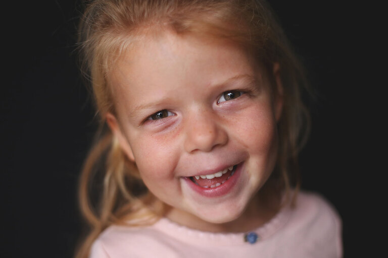 Little girl with red hair smiling and looking directly at camera | St. Louis School Photographer