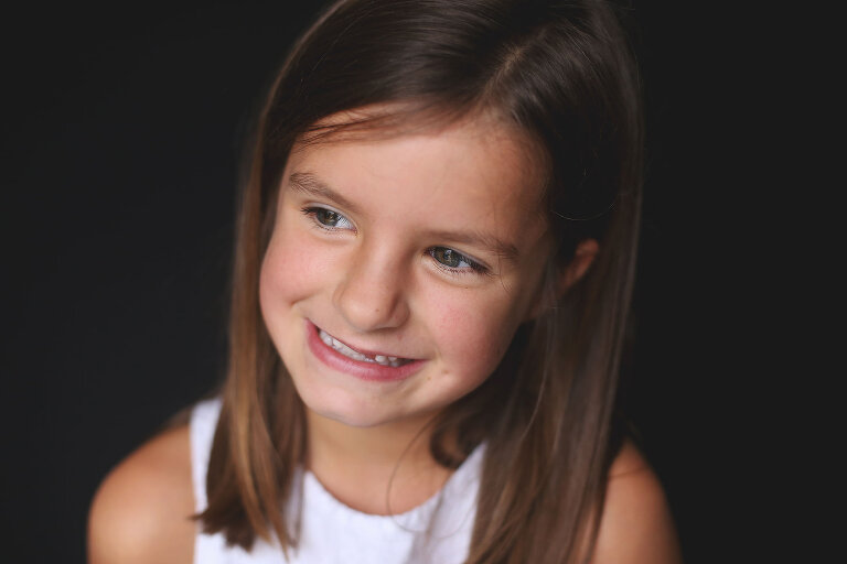 Young girl smiling and looking into the distance | St. Louis School Photography