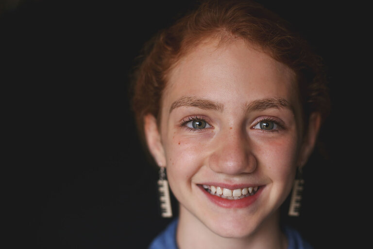 Red haired girl smiling at camera | St. Louis School Photography