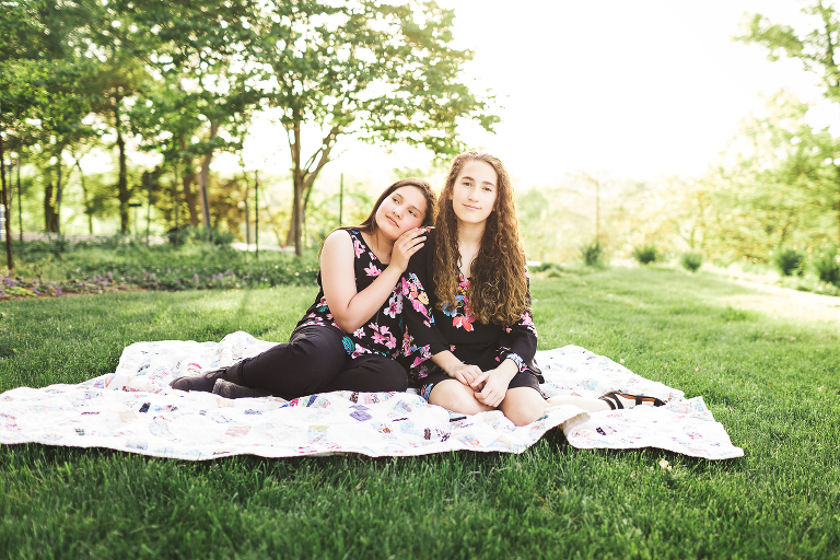 Two young ladies sitting on blanket in Queeny Park | St. Louis Family Portraits