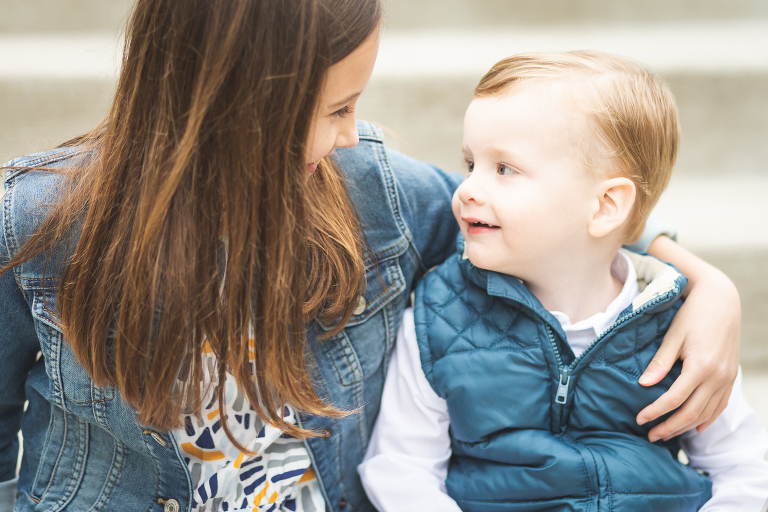 Little brother looking lovingly at big sister at Oak Knoll Park | St. Louis Family Photos