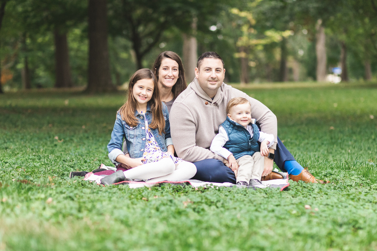Mom, Dad, and 2 kiddos sitting on blanket in Oak Knoll Park | St. Louis Family Photographer