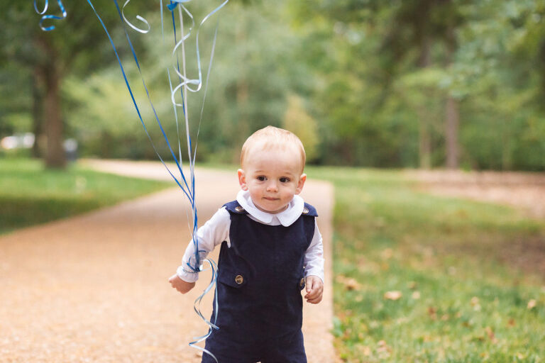 One year old boy with his birthday balloons at Oak Knoll Park | St. Louis Children's Photographer