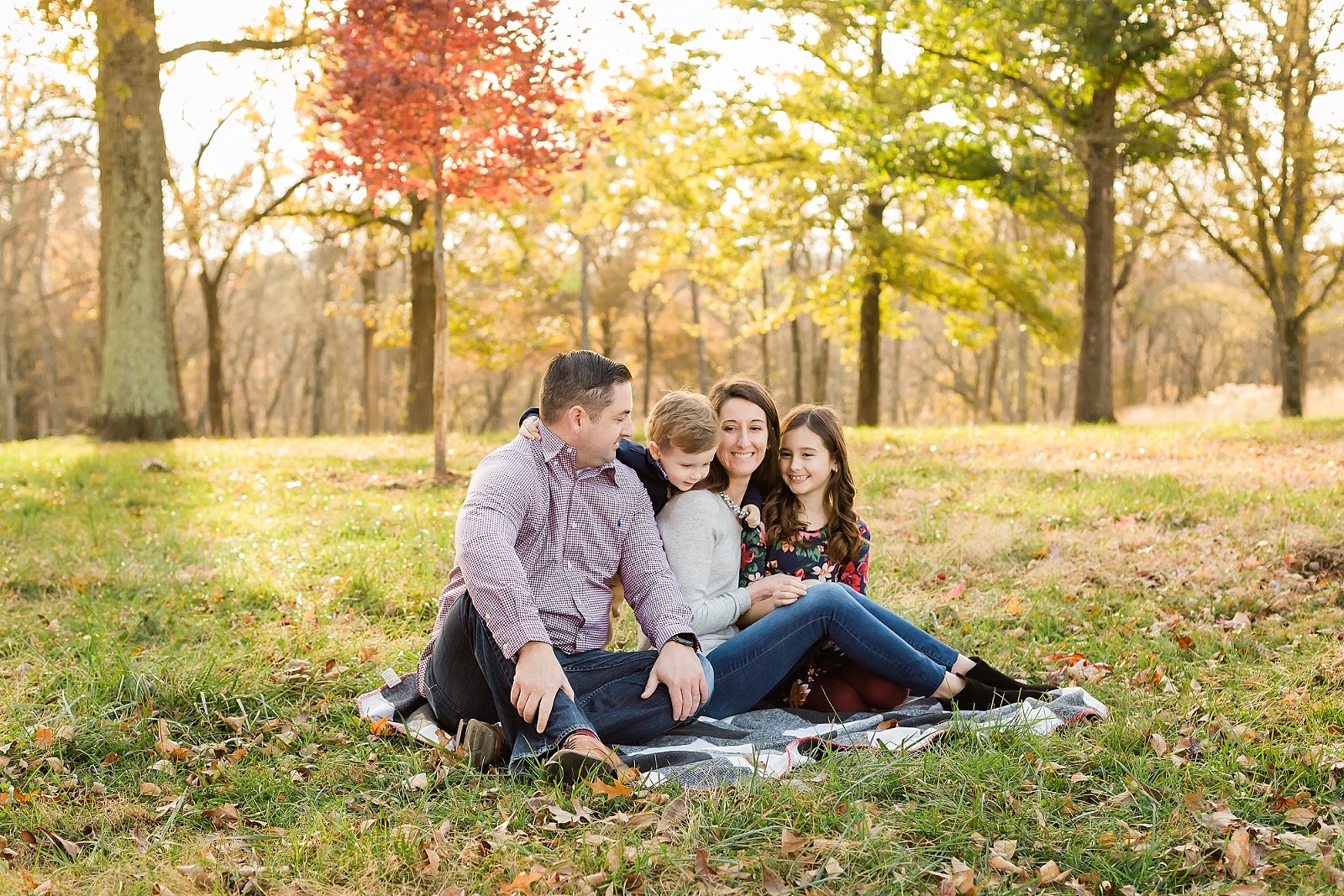 Family sitting on blanket in a field at Queeny Park | KGriggs Photography