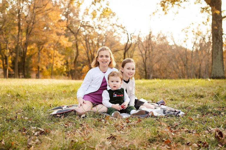 All three siblings sitting on blanket in park on fall evening | St. Louis Photographer