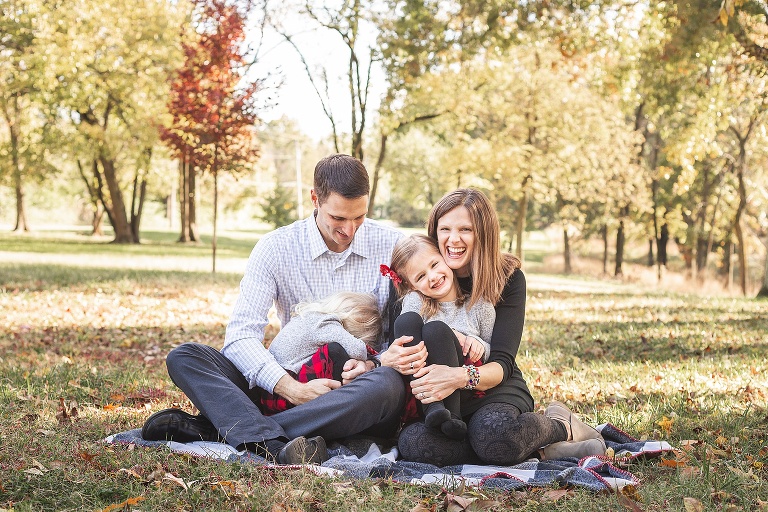 Sweet family with two little girls enjoying each other on blanket in park | STL photographer