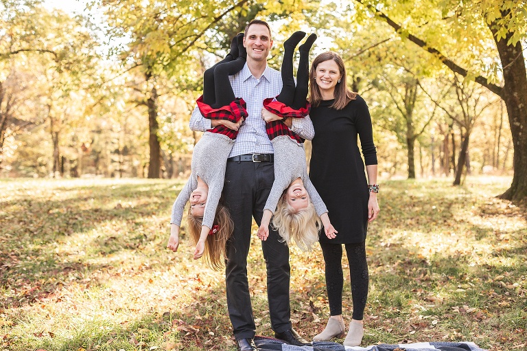 Dad holding 2 daughters upside down on fall evening | St. Louis Family Photographer