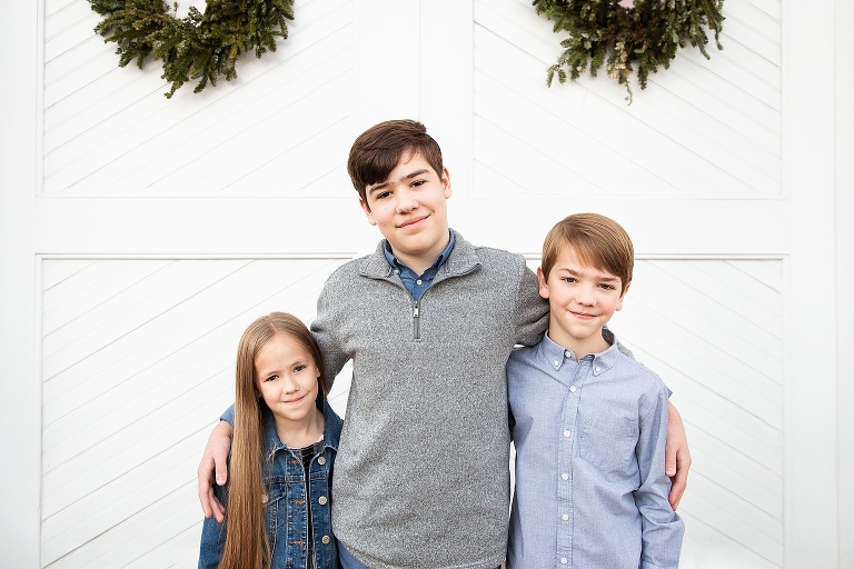 Three siblings in front of white barn doors | KGriggs Photography