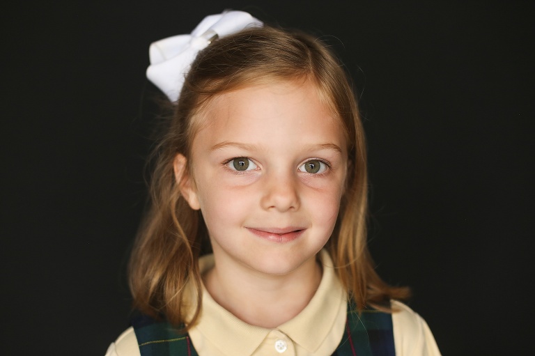 School photo of sweet young girl with white bow in hair | St. Louis School Photography