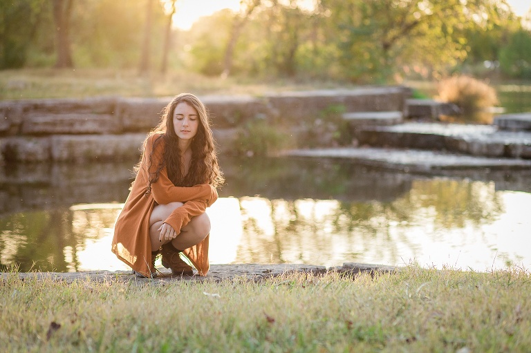 Kirkwood high school senior girl kneeling in Forest Park | St. Louis Photographer