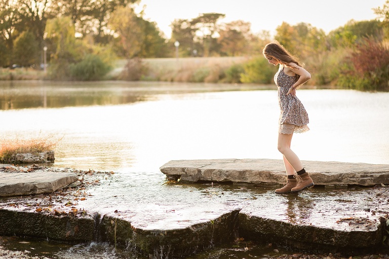 High school senior walking across rocks in Forest Park | St. Louis Senior Photographer